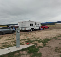 A class A motorhome in an rv site surrounde by green trees at Happy Acres RV Park in Pueblo, Colorado.